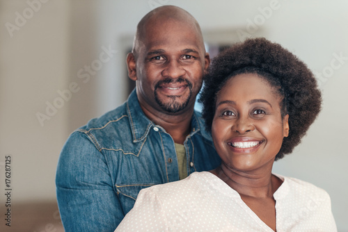 Content African couple smiling and standing together at home