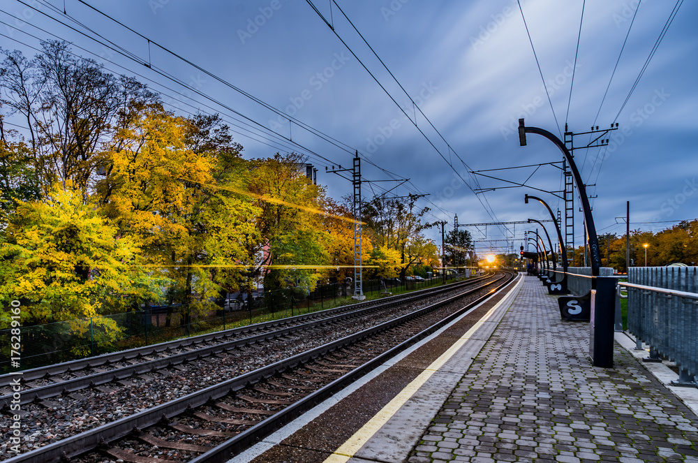 Fototapeta premium Railroad platform in autumn, with long exposure