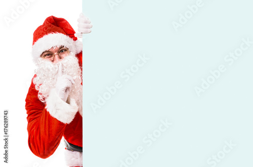 Santa Claus with finger on lips asking for silence, isolated on white background © Sergey Peterman