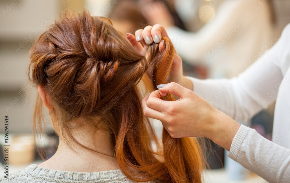 Beautiful, red-haired girl with long hair, hairdresser weaves a French braid, in a beauty salon. Professional hair care and creating hairstyles. Beautiful, red-haired girl with long hair, hairdresser weaves a French braid, in a beauty salon. Professional hair care and creating hairstyles.