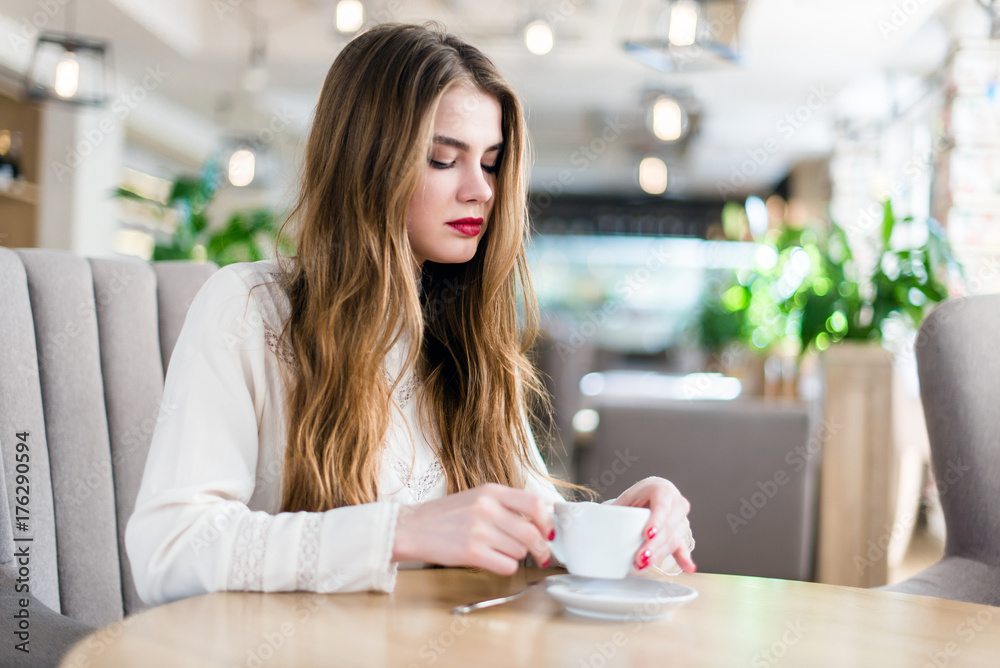 Beautiful young girl with professional makeup and hairstyle sitting in restaurant. Beautiful young girl with professional makeup and hairstyle sitting in restaurant.