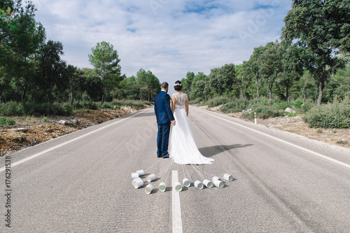 just married on the road with metal canisters