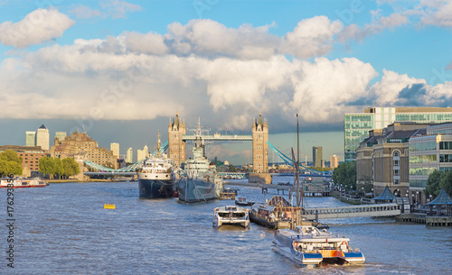 London - The panorama of the Tower bridge, riverside in evening light with the dramatic clouds.