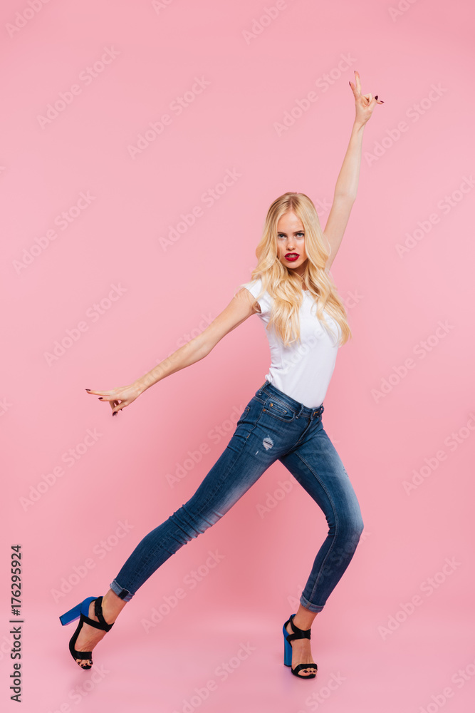 Full length image of attractive blonde woman posing in studio