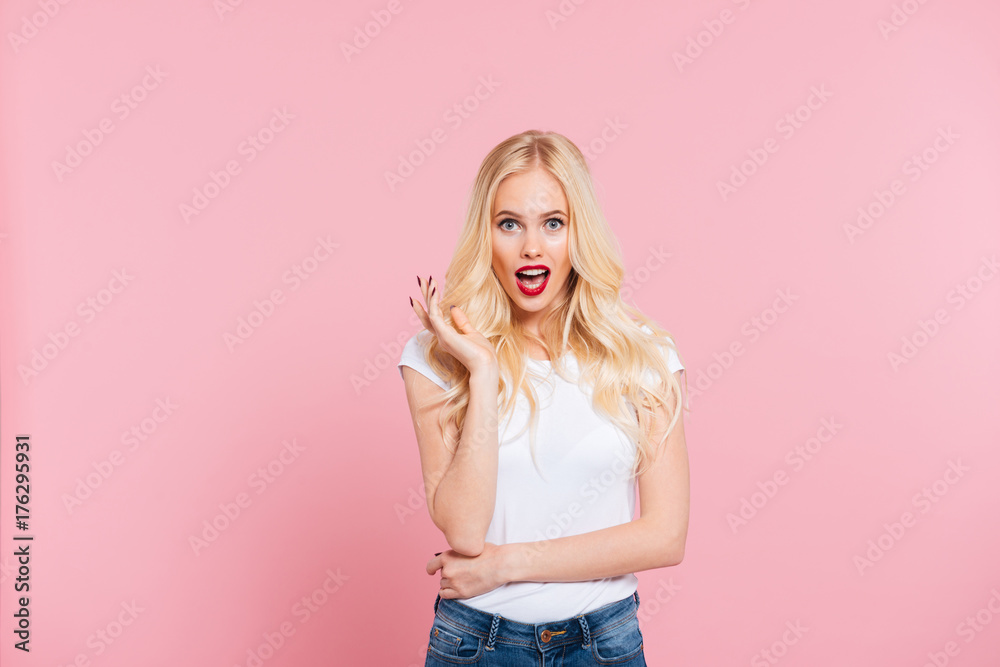 Shocked blonde woman looking at the camera with open mouth Shocked blonde woman looking at the camera with open mouth