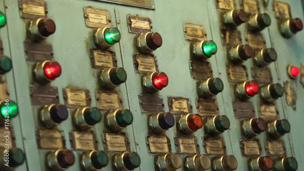 Flashing red and green lights inside keys of old central pane of production machine tool during operation. Automatical processes on industrial plant.