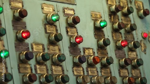 Flashing red and green lights inside keys of old central pane of production machine tool during operation. Automatical processes on industrial plant.