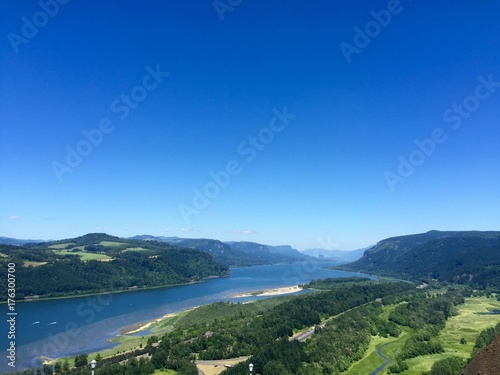 Oregon Landscape with its gorgeous rivers and mountains. Mother nature and its wonders. Nature background with sky, river and land. Simple earth backgrounds for presentations.  © Manasa