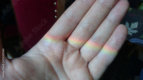Hand holding a rainbow