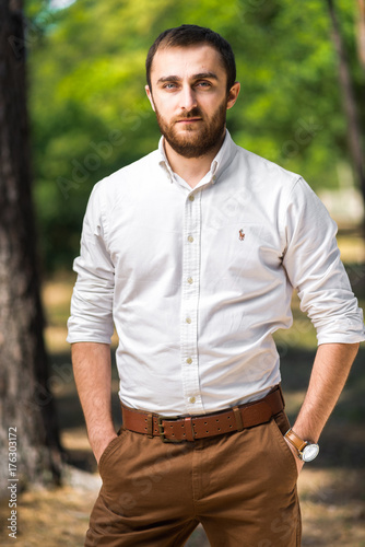 Handsome man wearing in casual white shirt looking straight into the camera