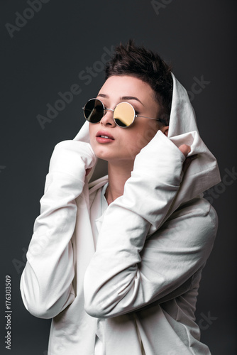 Portrait of a beautiful young girl wearing a white coat and sunglasses