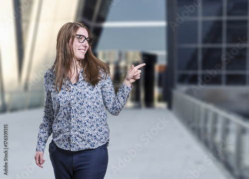 Pretty young business woman presenting something with black glasses