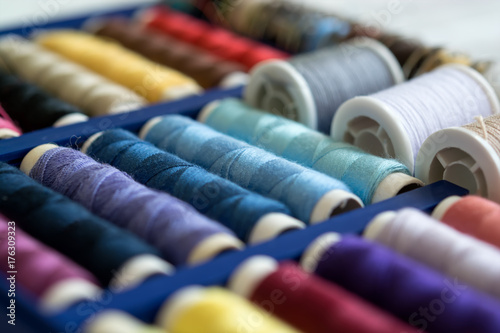 A lot of colorful sewing threads in the box. Selective focus  closeup.