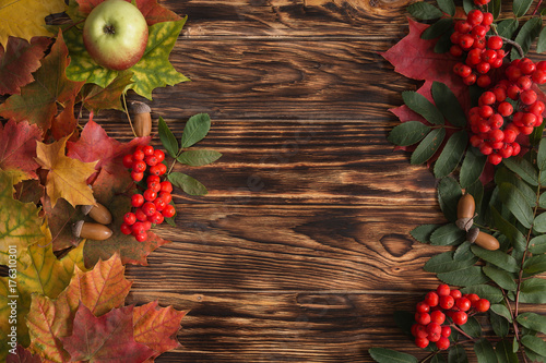 autumn, red, yellow leaves on wooden table (background) with apples and red ash.