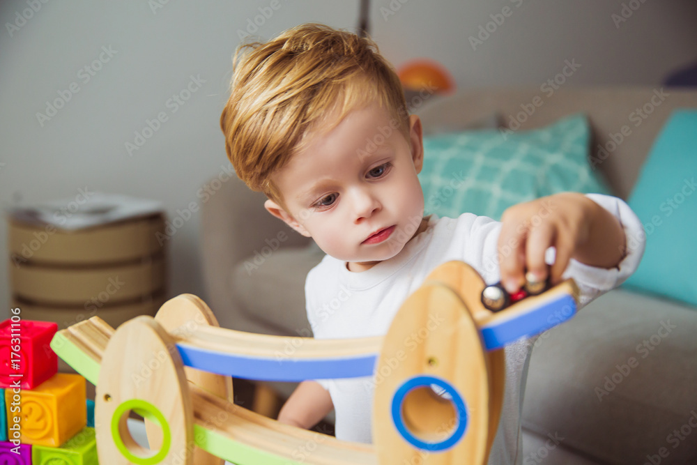 Portrait of little serious boy who playing with toys in the room Portrait of little serious boy who playing with toys in the room