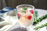 Glass with fresh rosemary drink on table
