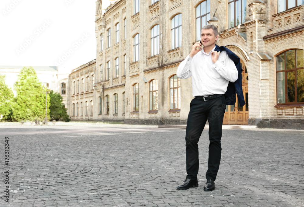 Elegant businessman talking on mobile phone outdoors Elegant businessman talking on mobile phone outdoors