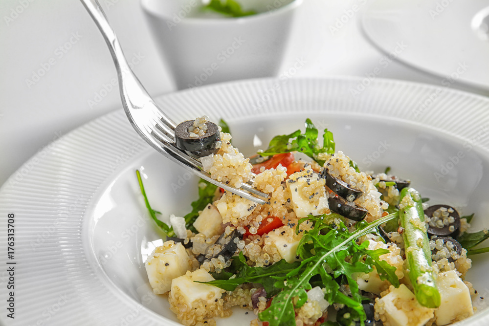Fork and plate with delicious quinoa salad, closeup Fork and plate with delicious quinoa salad, closeup
