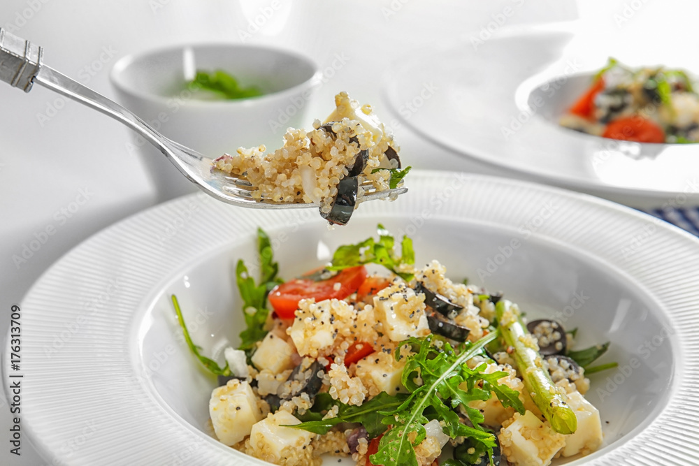Fork and plate with delicious quinoa salad, closeup