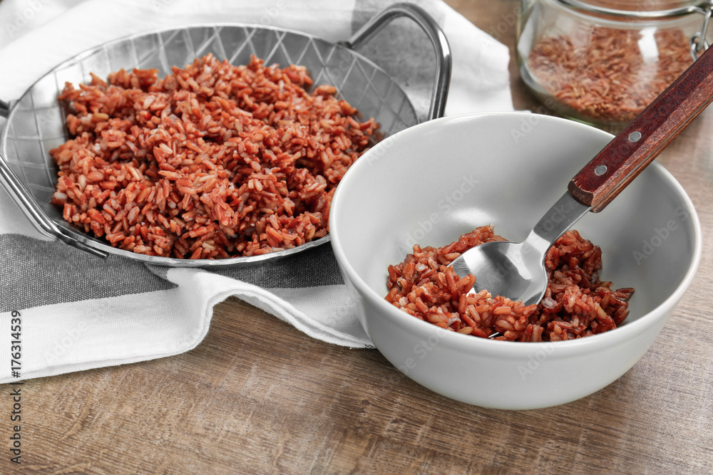 Bowl and dish with cooked rice on table