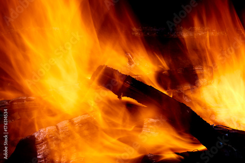 Burning firewood in the fireplace close up photo.