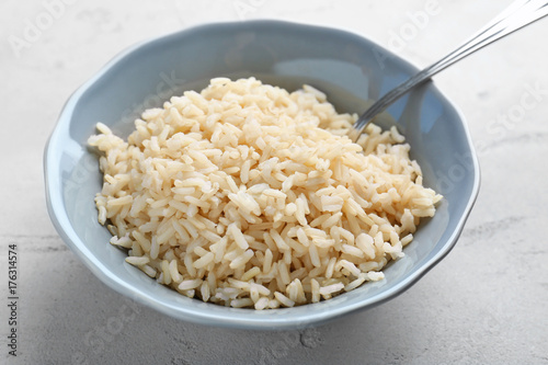 Bowl with cooked rice on table