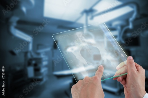 Composite image of hands of female doctor using digital tablet