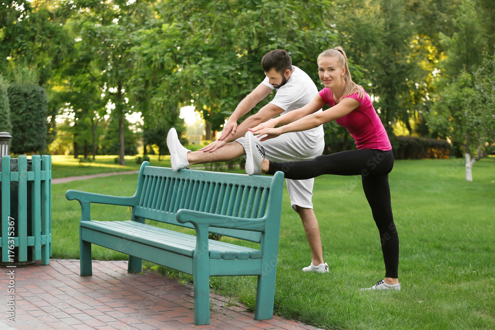 Young sporty couple doing exercise in green park Young sporty couple doing exercise in green park