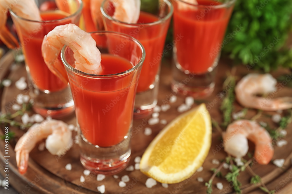 Shrimps and tomato sauce in glasses on wooden board, closeup
