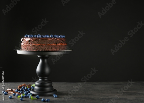 Stand with chocolate cake on table