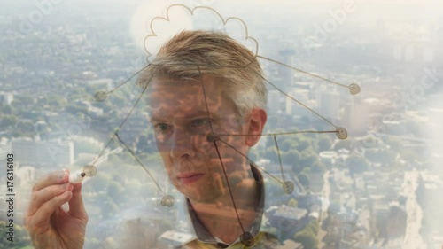 Reflection of a businessman drawing an image of a cloud network photo