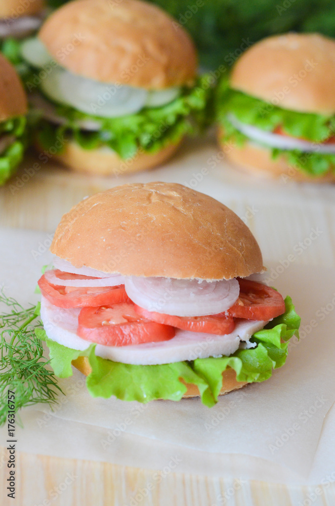 sandwich with tomato lettuce and ham and onion on a wooden table sandwich with tomato lettuce and ham and onion on a wooden table