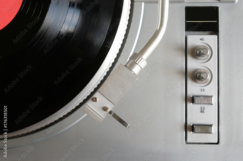 Vintage turntable in silver case with buttons and knobs on control panel  with vinyl record with red label studio shot top view Stock Photo | Adobe  Stock