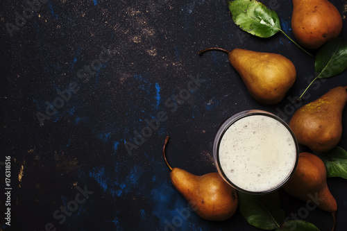 Pear cider in a large beer glass, dark background, top view