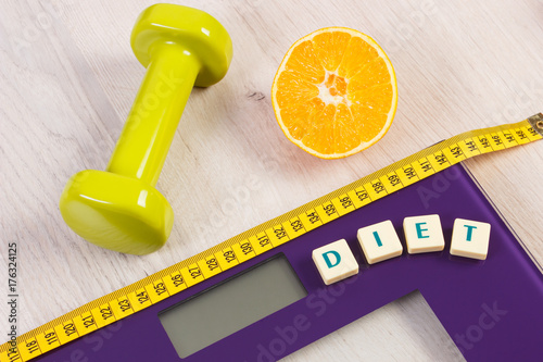 Digital bathroom scale with tape measure, orange and dumbbells, slimming concept