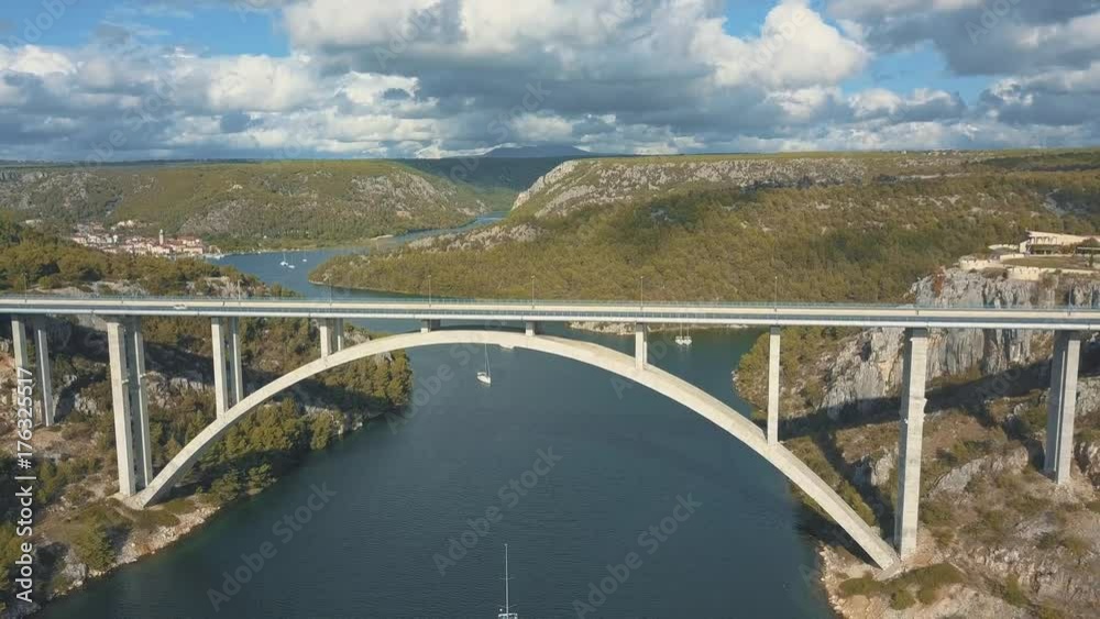 Aerial panorama view with bridge and sea around islands. Beautiful landscape surrounded with blue sea with bridge between. Autostrada bridge with traffic over Krka river at sunny day in Croatia.