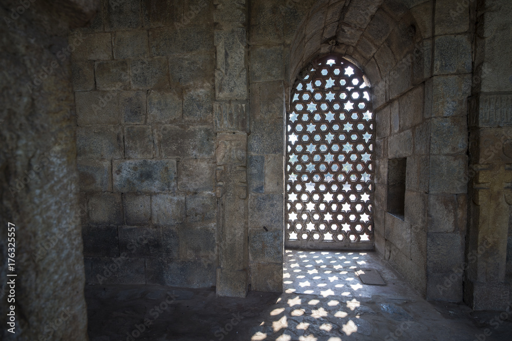 Some rays of sunshine pass through a door inside the Qutub Minar complex in New Delhi in India.