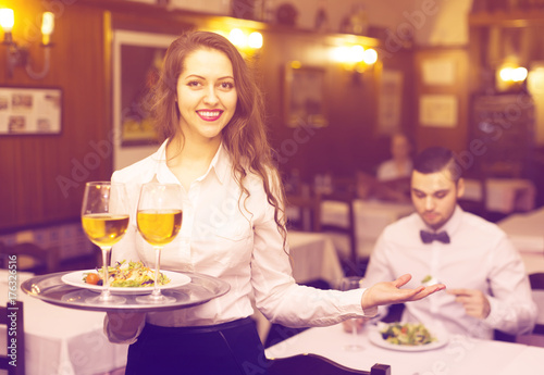 waitress with prepared meal at table