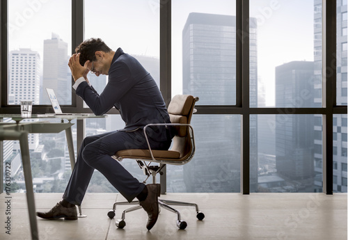 Stressed young businessman overworking photo