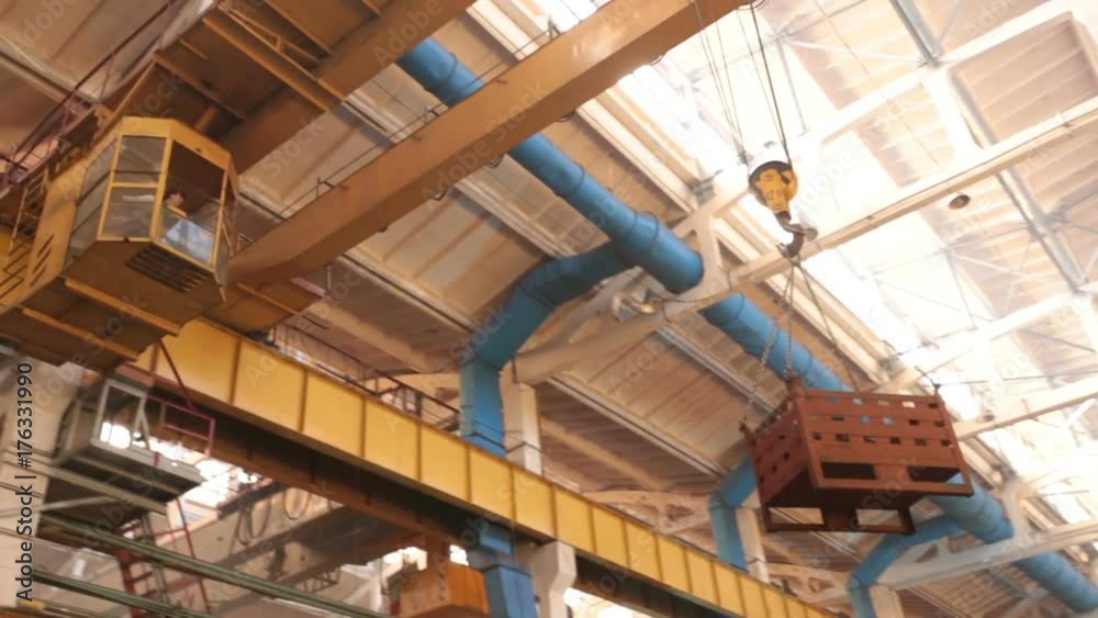 the crane beam delivers the container. At the factory there is a cradle with details, a heavy load. the crane beam delivers the container. At the factory there is a cradle with details, a heavy load.