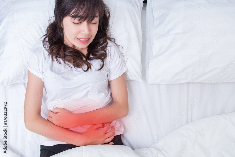 Woman stomach pain on her bed. concept for healthy Woman stomach pain on her bed. concept for healthy