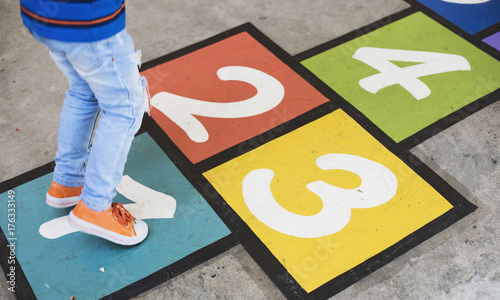 Quadro su tela Kid playing hopscotch at school