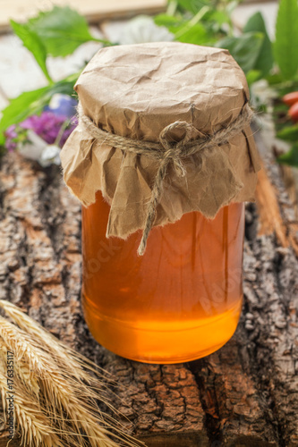 Jar of liquid honey on wooden background