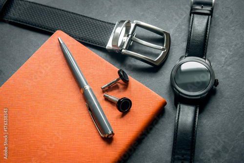 Elegant men`s business accessories. Black watches, belt, notepad, pen, cufflinks. 