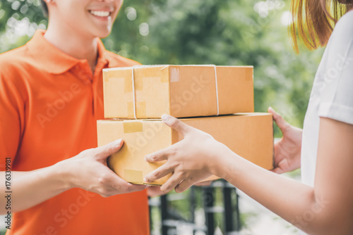 Fotografía Smiling delivery man delivering parcel to a woman