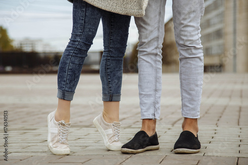 Closeup of feet of young people kissing and walking in the city