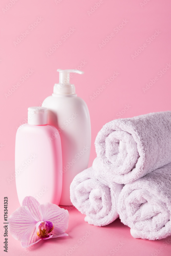 Towels with shower gel and body lotion on pink background. Towels with shower gel and body lotion on pink background.