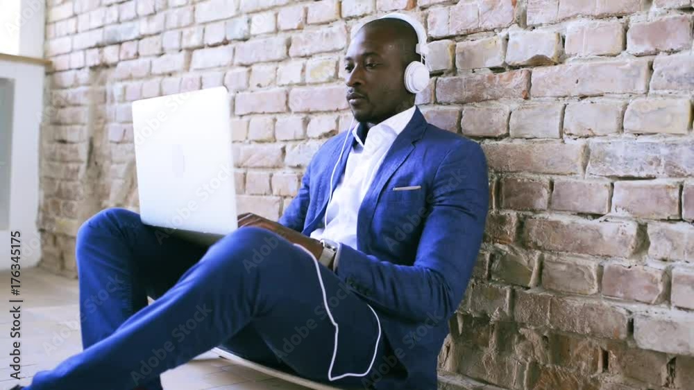 African businessman with laptop and headphones. African businessman with laptop and headphones.