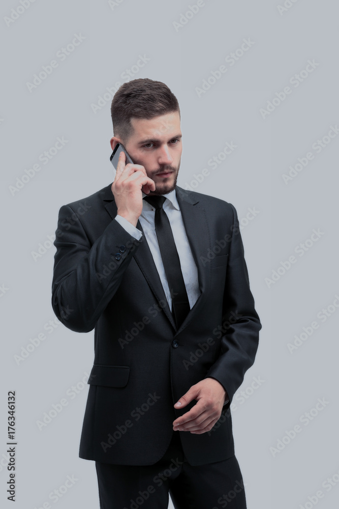 Handsome businessman in suit using the phone in office