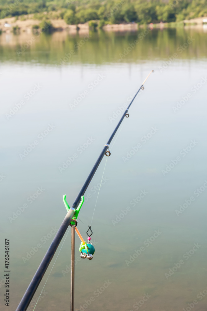 Part of a fishing rod on water background. Selective focus